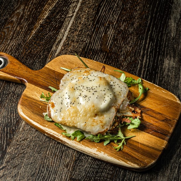 Venezuelan cachapas topped with melted cheese and chia seeds, served on a wooden board.